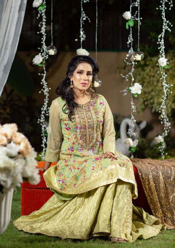 Light grren jamawar gharara style with A-Line pannelled shirt in net fabric having multi color embroidery and heavily embellished neckline of tilla, naqshi, dapka, stonework on it.
