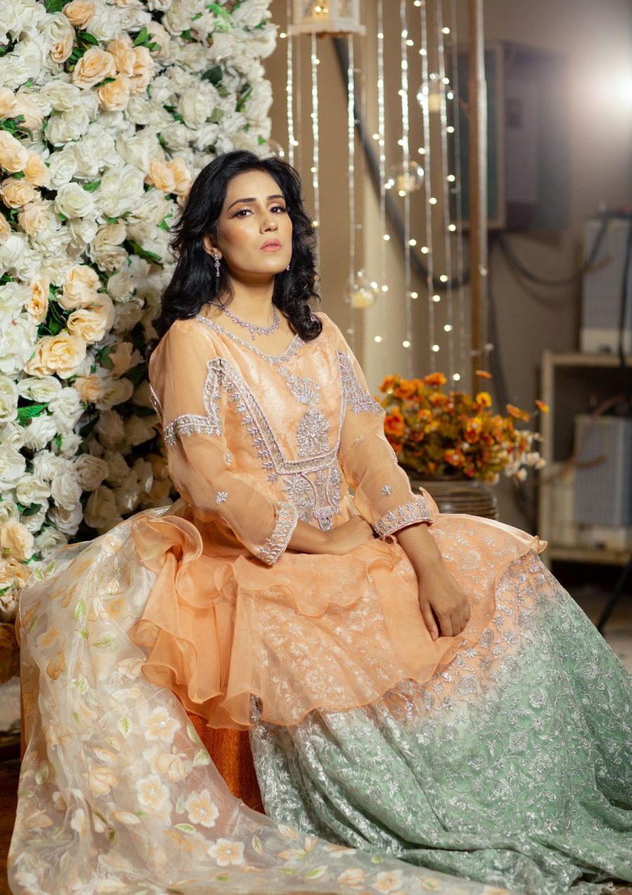 Peachy stylish flared short length peplum in organza fabric with silver hand work of naqshi, dapka, stones on it paired with peach and green shaded tye and dye fully embroidered net lehnga with silver tilla work on it also having printed organza dopata makes the look perfect for the wedding season.